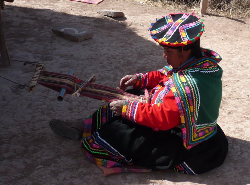 Man weaving by the side of the road near a local market